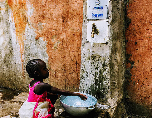 Young girl using the eWater tap hardware in the Gambia