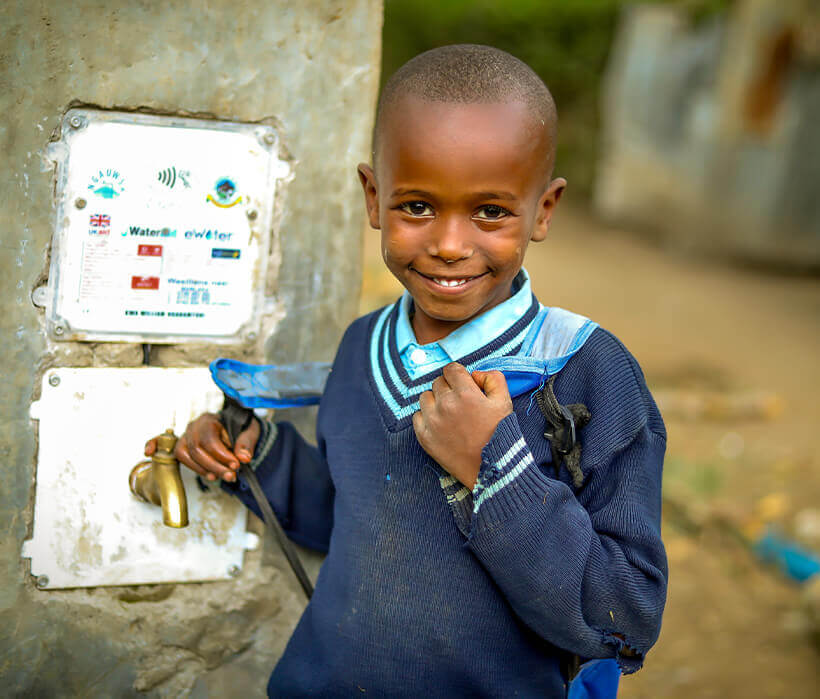 Young boy using eWater tap in The Gambia Hardware Development